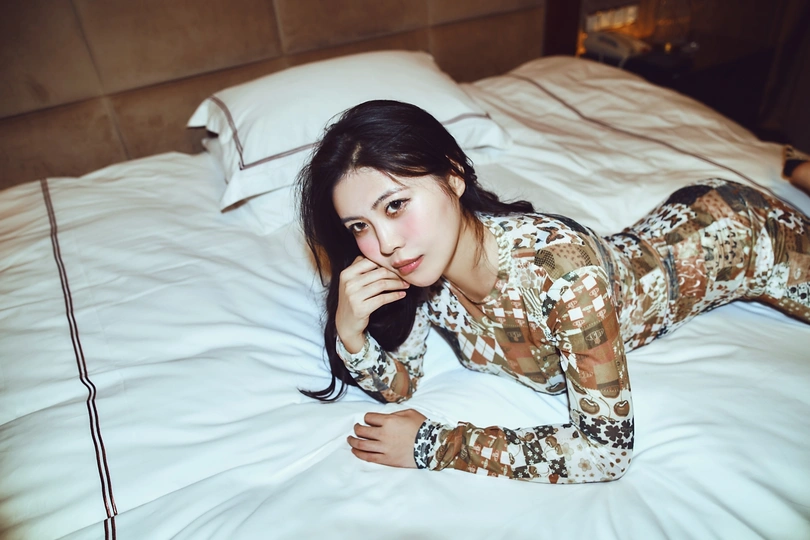 一个穿着军装的年轻女子躺在白色的床上