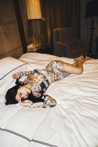 一个穿着白色连衣裙的美丽年轻女子躺在白色床上