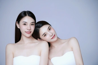 两位年轻女性在蓝色背景前摆姿势