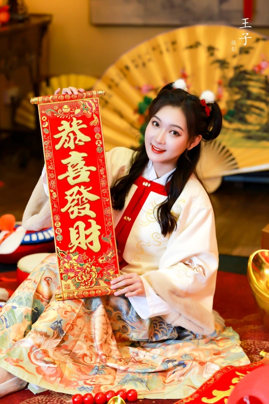 一位穿着中国传统服装的年轻女子抱着一个红人