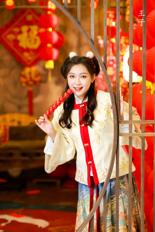 一位穿着传统服装的年轻女子在红灯笼前摆姿势