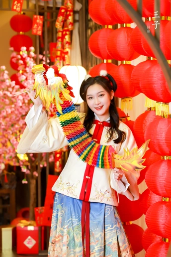 一位穿着 colorful 传统服装的年轻女子在红灯笼前摆姿势