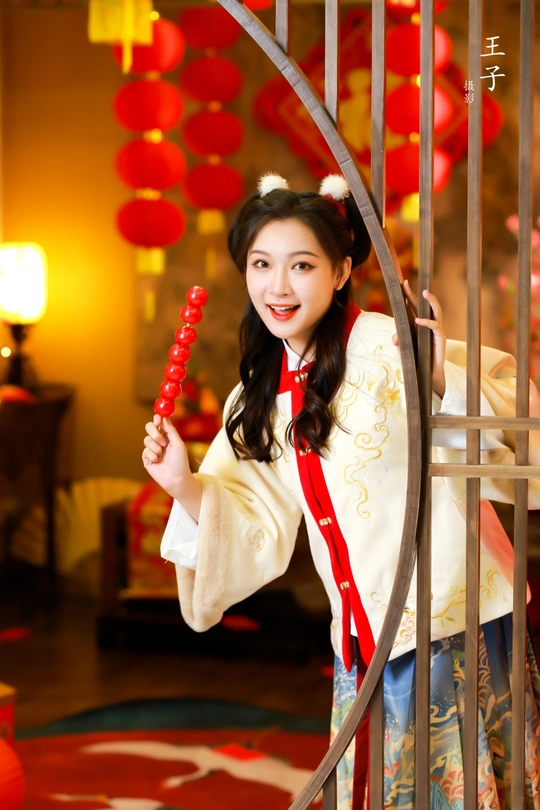 一位穿着中国传统服装的年轻女子手持红色雨伞