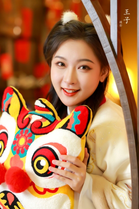 一位穿着传统服装的年轻女子与一个充气玩具合影。