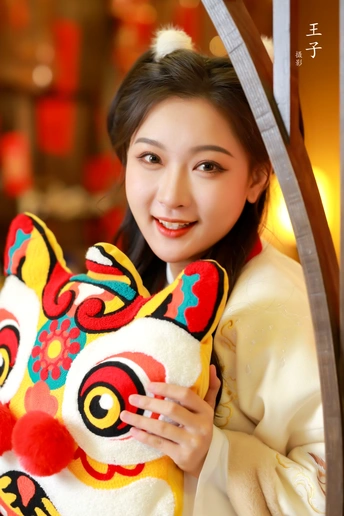 一位穿着传统服装的年轻女子与一个充气玩具合影。