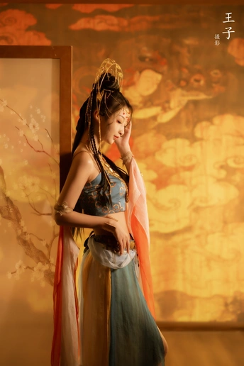 一位穿着传统服装的年轻女子站在一幅画前