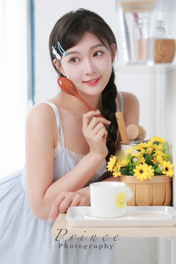 一位穿着白色连衣裙的年轻女子坐在一张带有黄色花朵的桌子旁