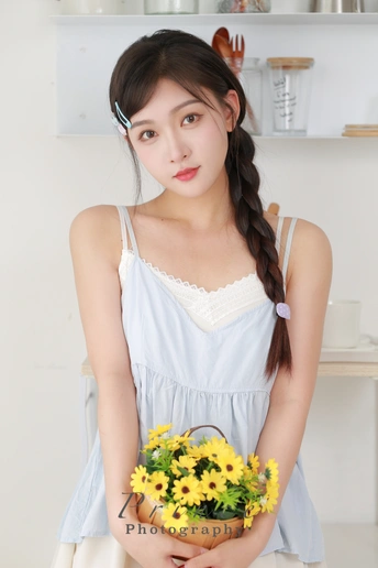 一个穿着白色连衣裙的年轻女子抱着一个篮子里的黄色花朵