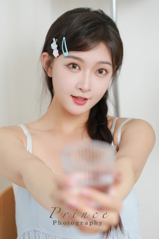 一位年轻女子手里拿着一杯水