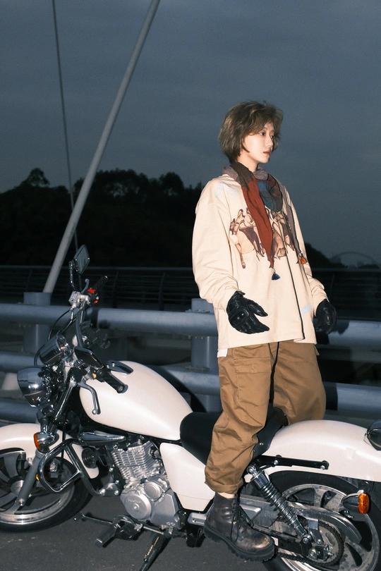 站在一辆白色摩托车旁的年轻女子