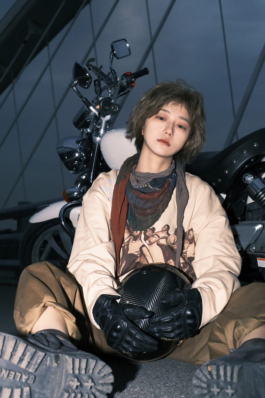 一个年轻人坐在摩托车上 戴着手套摆姿势