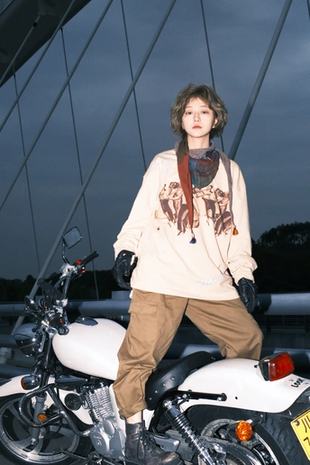 站在一辆白色摩托车旁边的年轻人