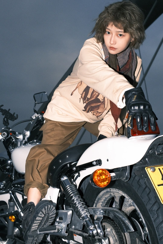 一个年轻男子坐在白色摩托车上摆姿势