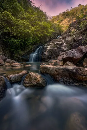 a small waterfall in a stream of water in the fore