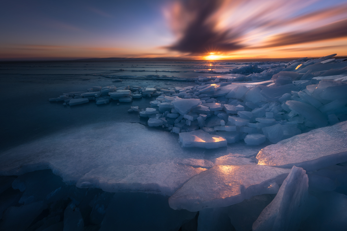 夕阳下海洋中的冰山 天空中太阳和云彩