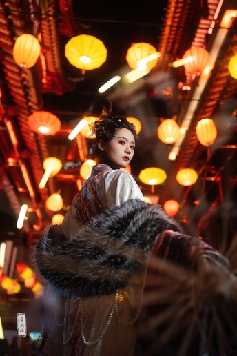 一位年轻女子站在节日点亮的灯笼前