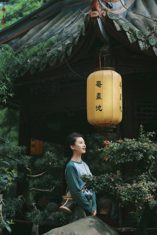 和服女性站在神社前的岩石上 灯笼悬挂在头上