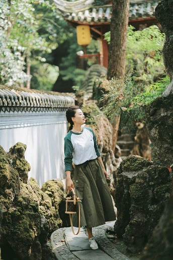 一位站在寺庙前的岩石上的女人