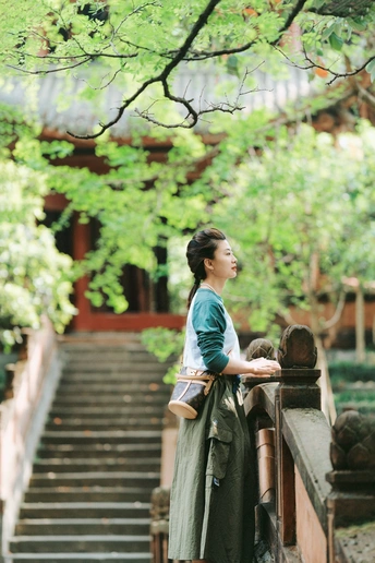 一位年轻女子站在寺庙的台阶上