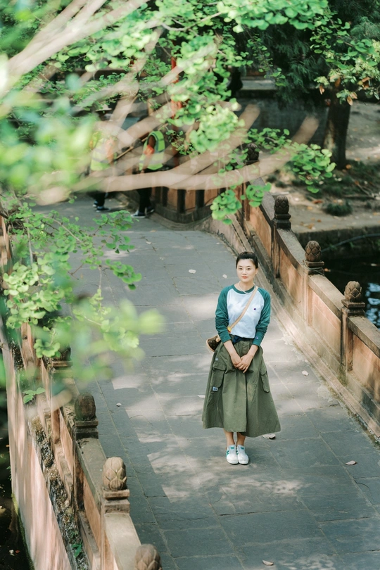 站在河边和树旁的年轻女子