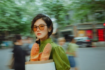 戴眼镜的女人提着食物袋走下街道