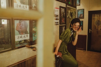 一位坐在绿色自行车上的女人正在打电话