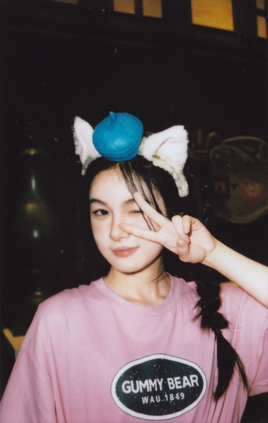 一位穿着粉红色衬衫和蓝色帽子的年轻女子