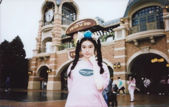 一位穿着服装的年轻女子站在一栋建筑前