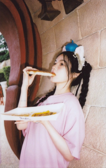 一位年轻女子举着盘子送到嘴边