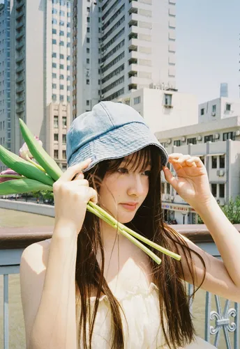 一位戴蓝帽子的年轻女子抱着花