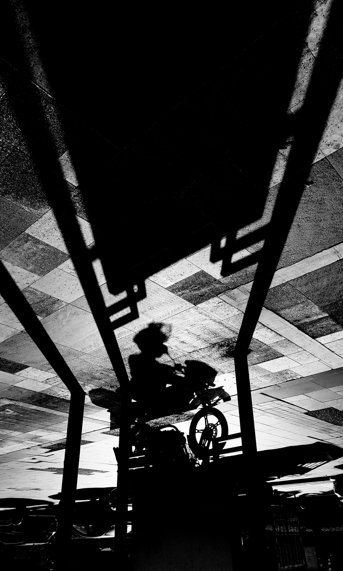 一个男人在大楼里骑摩托车的黑白影子