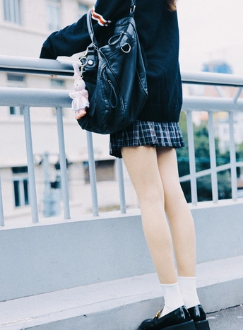 一位穿着黑色裙子和袜子的年轻女子