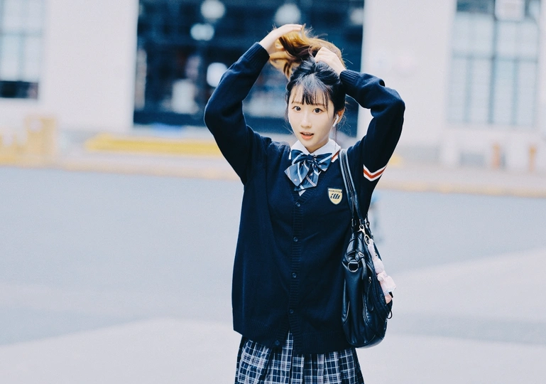 一位女孩穿着校服在街上 头发飘在空中