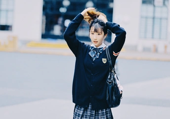一位女孩穿着校服在街上 头发飘在空中