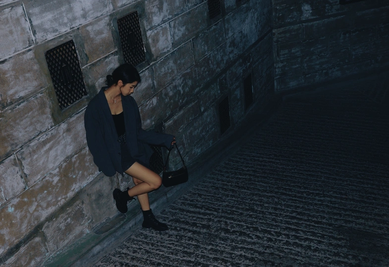 一个穿着黑色连衣裙的女孩走下楼梯