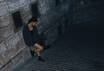 一个穿着黑色连衣裙的女孩走下楼梯