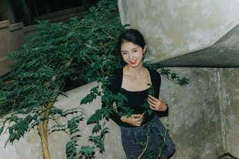 站在有植物的墙边的年轻女子