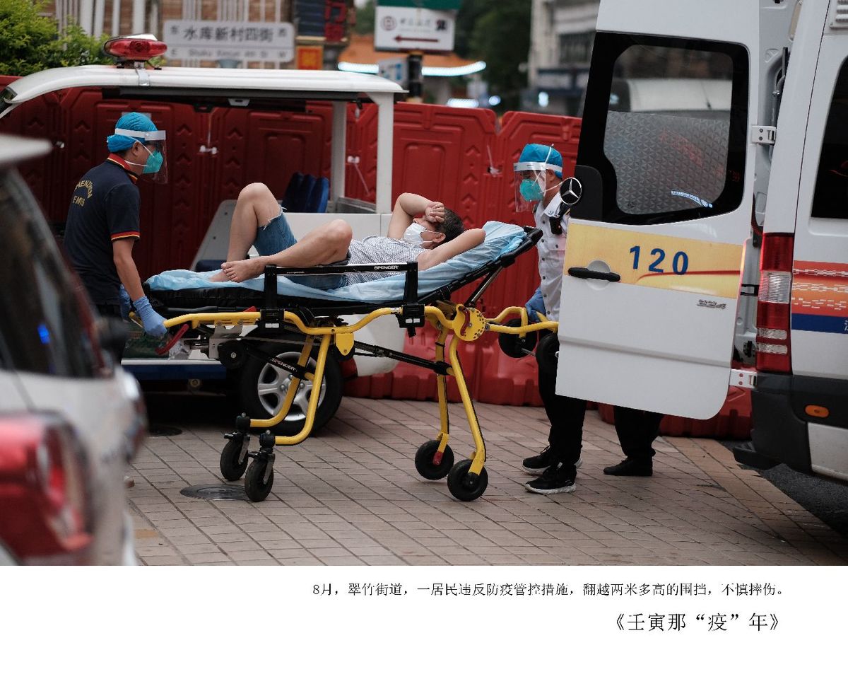一位男子躺在靠近救护车的繁忙街道上的床上。