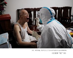 一位老人和一位年迈的女人坐在医疗室的相邻位置。