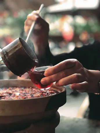 一个女性正在往食物碗里倒红酒