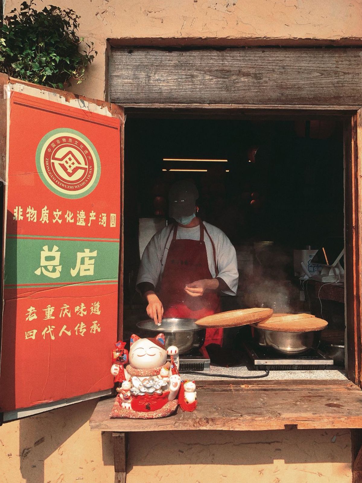 一个站在小建筑外面用锅铲烹饪食物的男子
