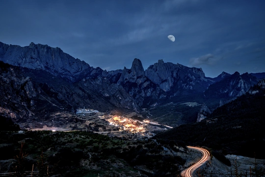 夜晚 满月照亮了镇上上方的高山。