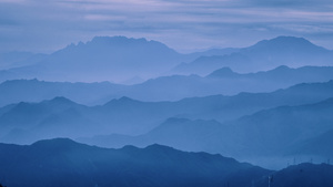 日落时分的山脉 山谷中有蓝天和雾气。