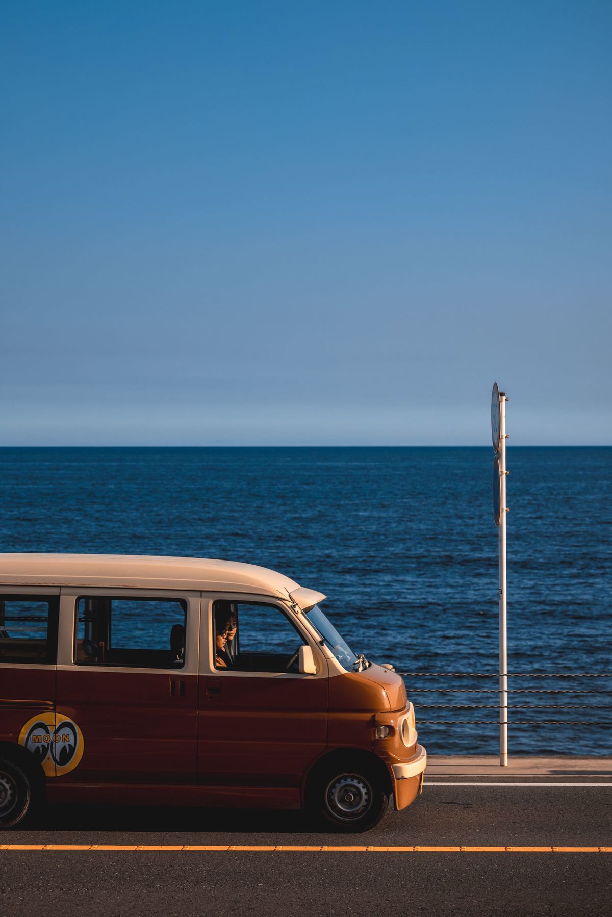 路边停着一辆停在海洋和海滩附近的车。