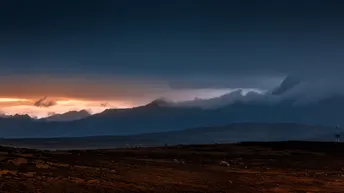 背景是山脉 天空中云朵 一个田野