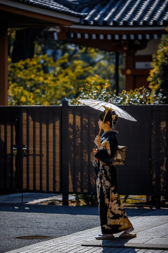 一个人穿着和服拿着雨伞走在大街上