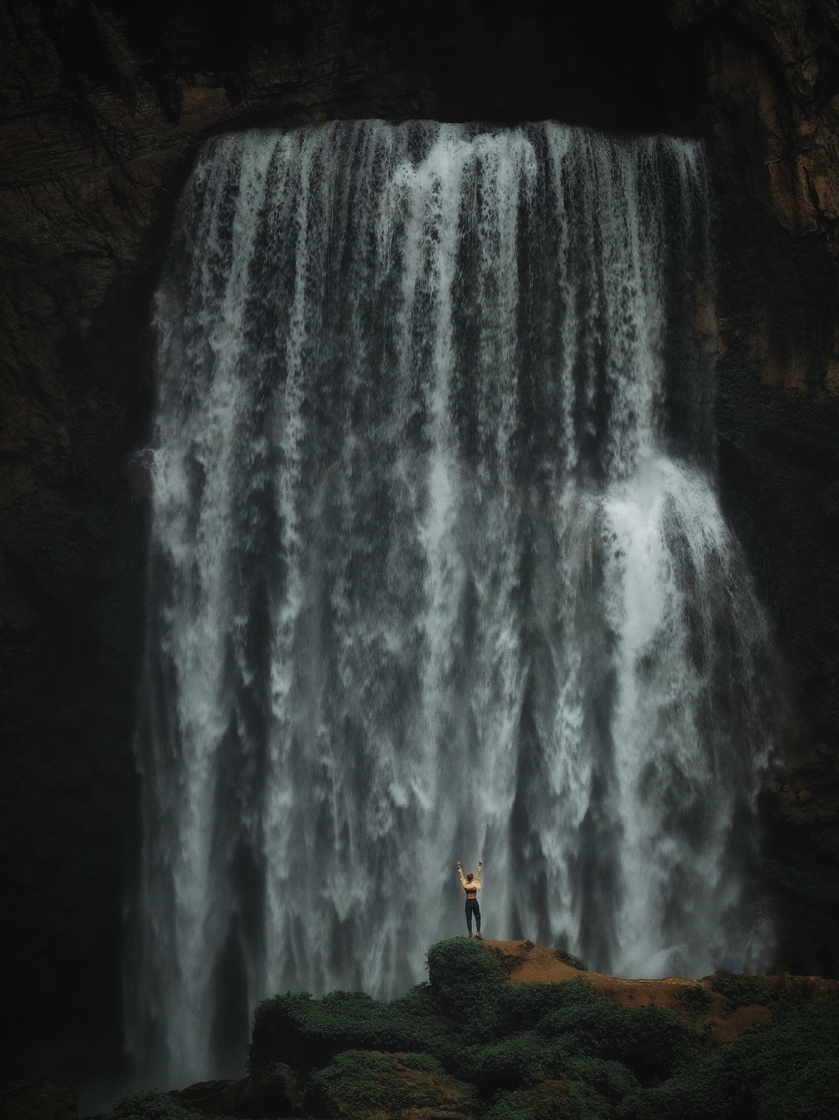 站在大型瀑布底部的一个男人