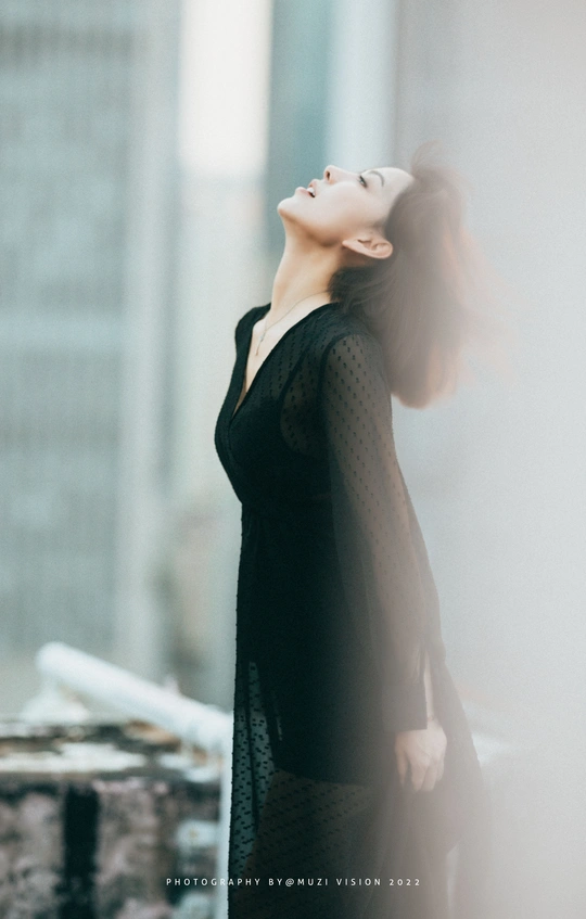 一个穿着黑色连衣裙的女人站在建筑区