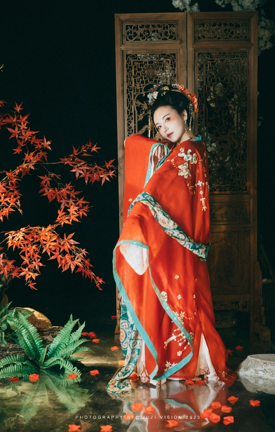 一位穿着红色传统和服的年轻女子站在水中