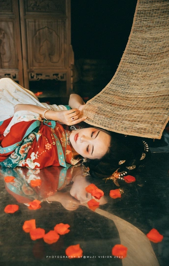 一个年轻女子躺在地上 全身覆盖着花瓣和鲜花。